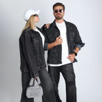 alt=“ست زوجی با جکت جین زغالی ساده DO57، استایل یونی‌سکس زغالی با تیشرت سفید و کفش اسپرت، پس‌زمینه شهری مدرن.”